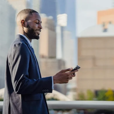 Un-homme-souriant-tenant-son-mobile-à-la-main
